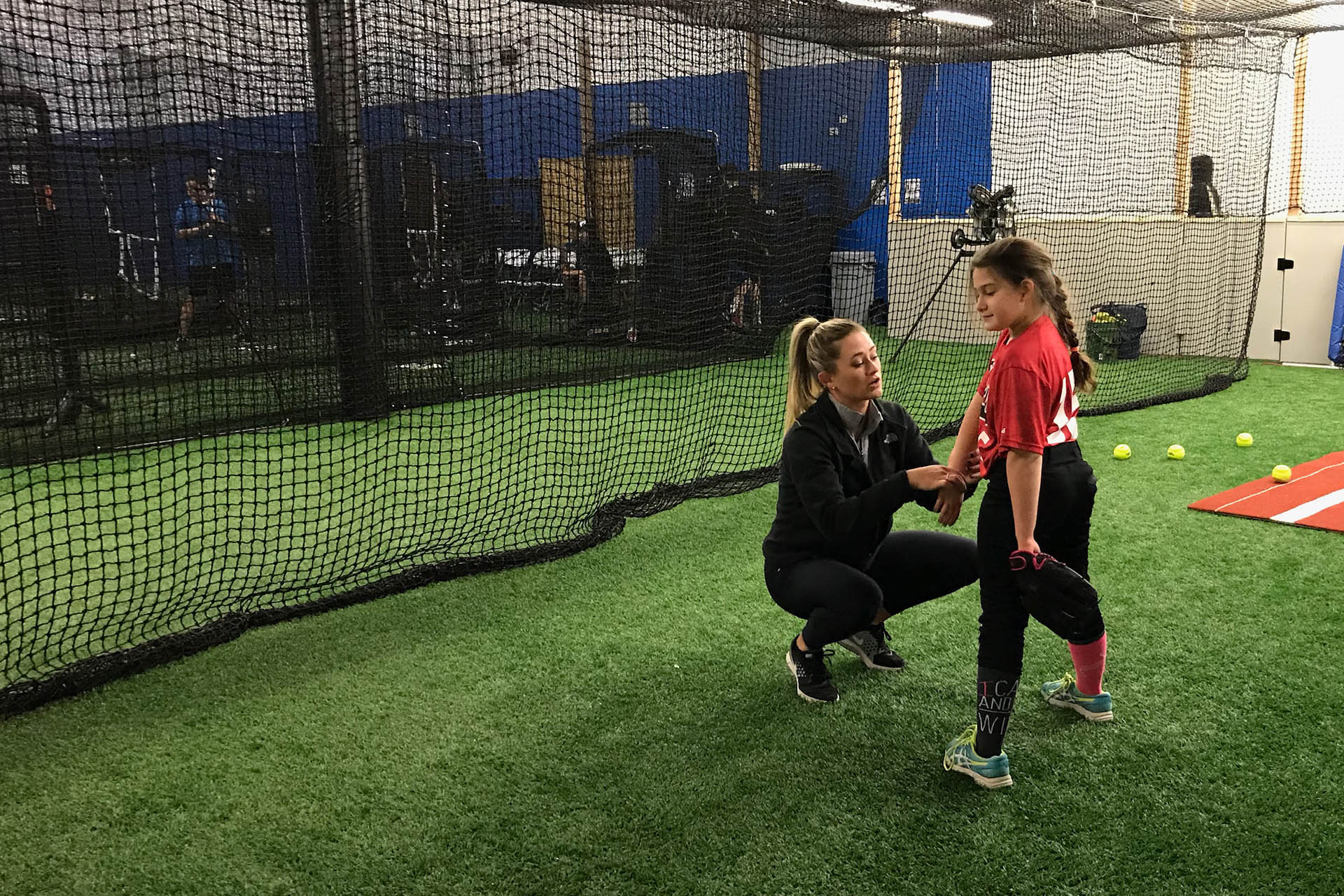 Softball pitcher teaching young girl