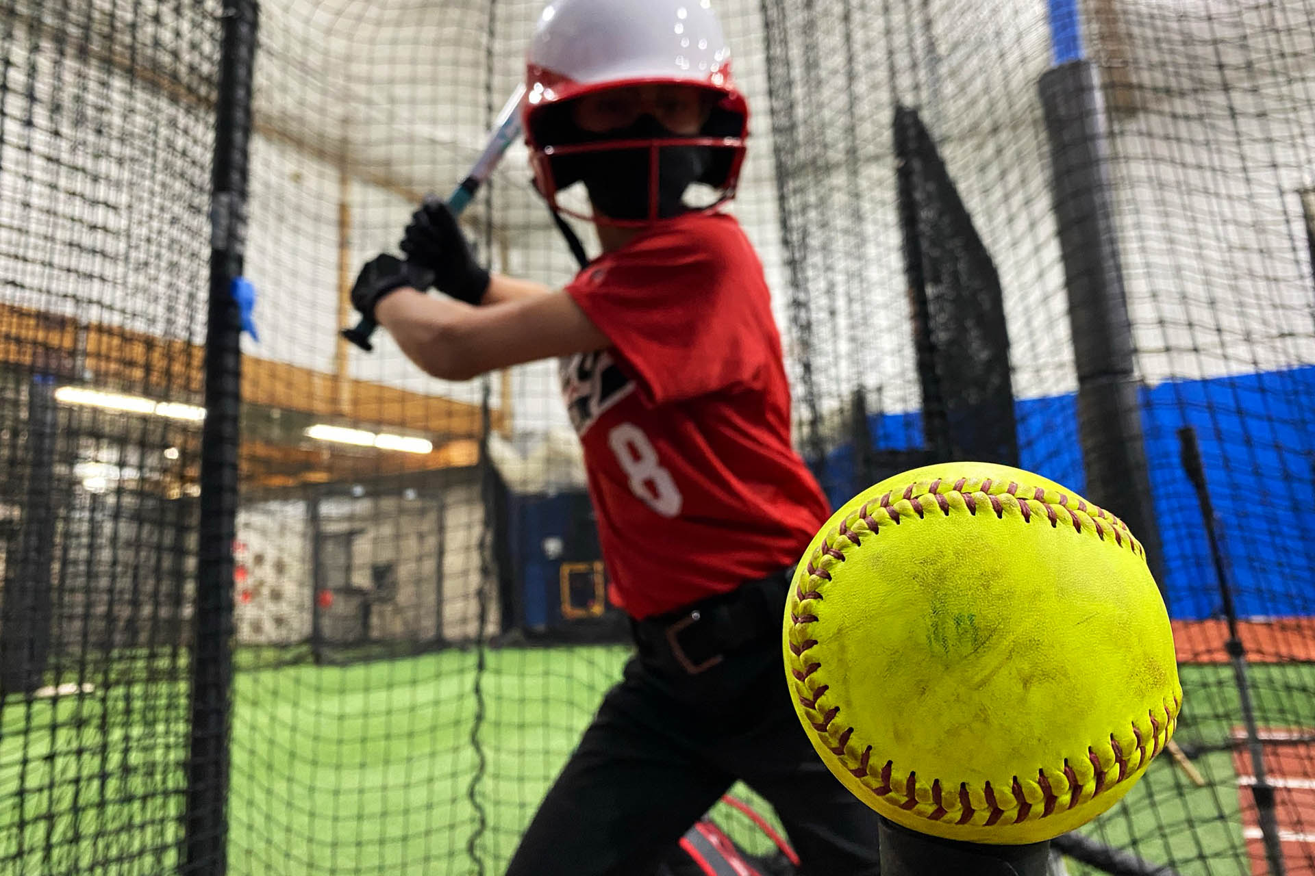 Girl Hitting a Softball Off a Tee