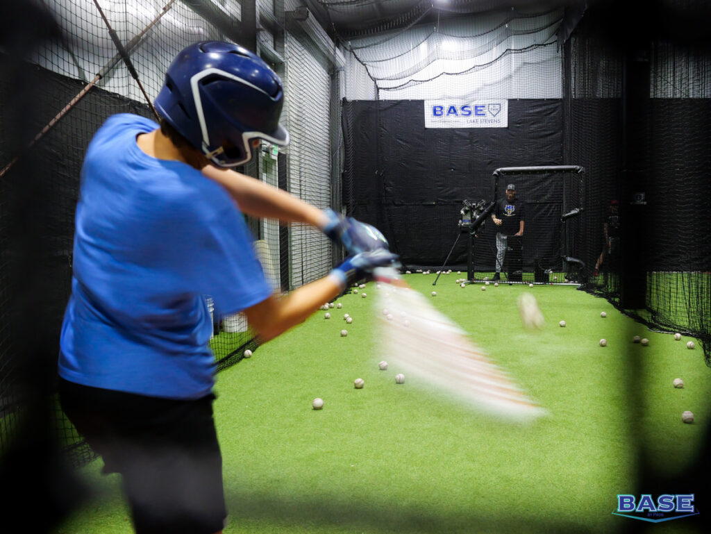 View Through the Net of a Boy Hitting a Baseball at BASE by Pros in Lake Stevens