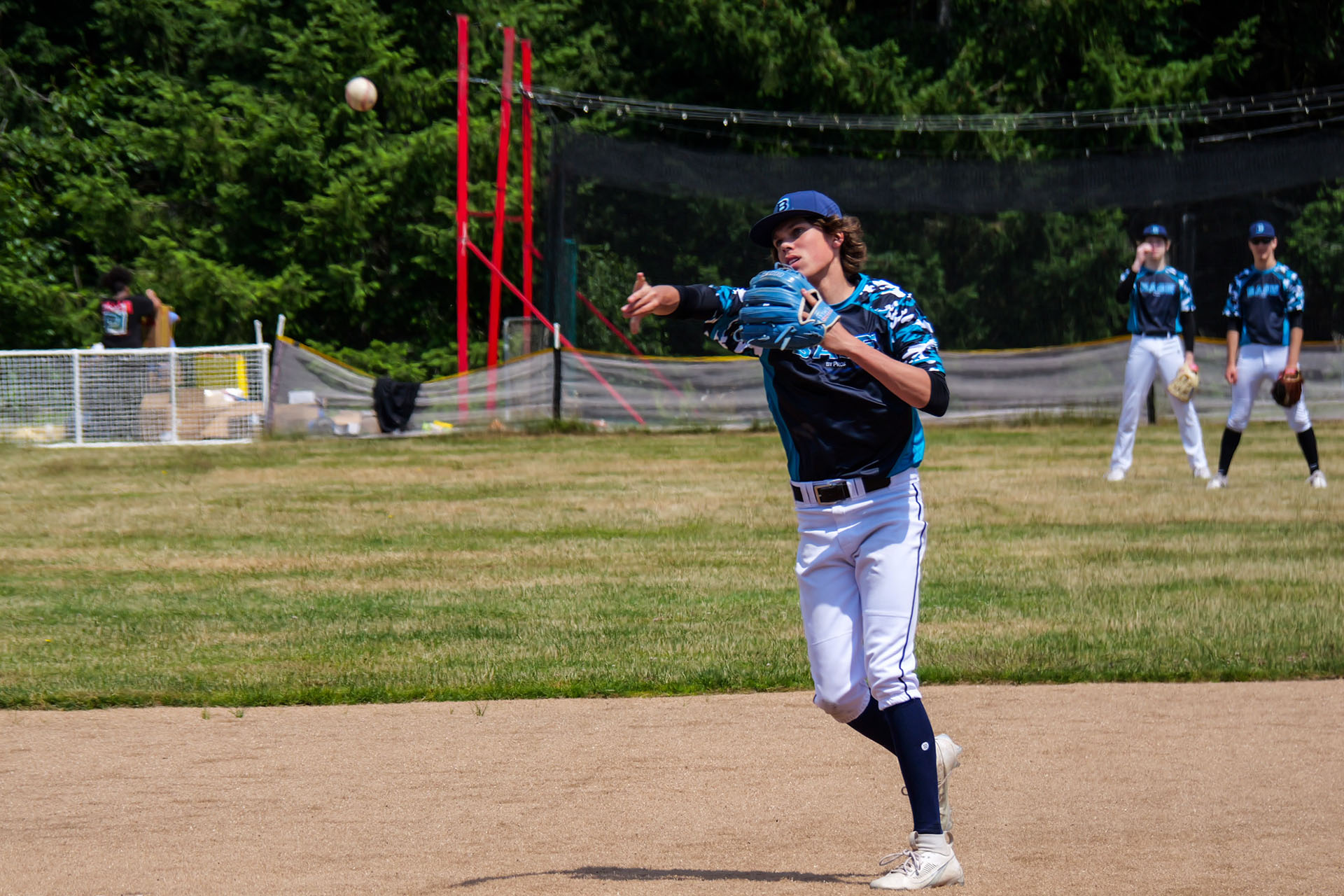 High School Summer League Shortstop Throws Baseball